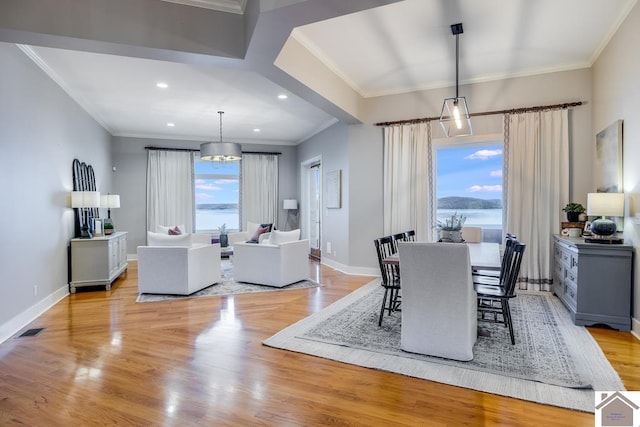 dining room with plenty of natural light, ornamental molding, and light hardwood / wood-style floors