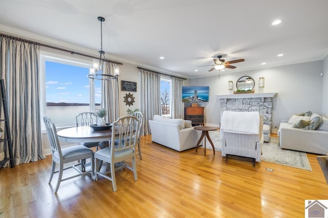 dining room with plenty of natural light, ceiling fan with notable chandelier, and light hardwood / wood-style floors