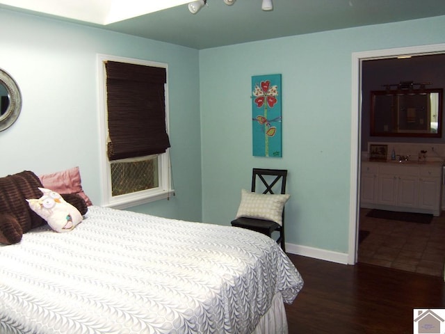 bedroom with dark wood-type flooring and ensuite bath