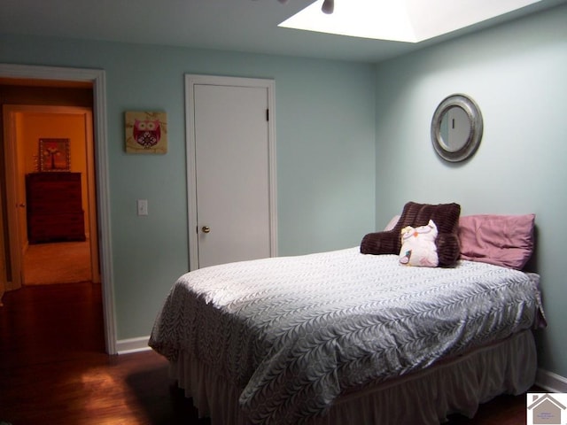 bedroom featuring dark hardwood / wood-style floors and a skylight