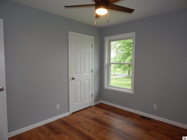 empty room featuring plenty of natural light, ceiling fan, and wood-type flooring