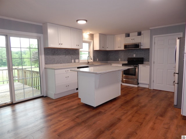 kitchen featuring a center island, appliances with stainless steel finishes, dark hardwood / wood-style floors, backsplash, and sink