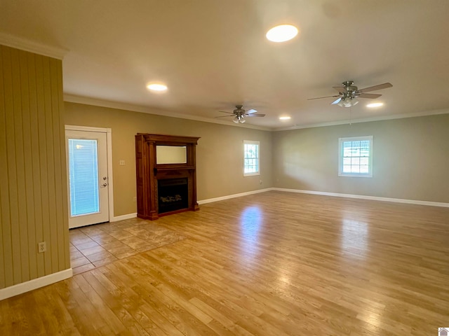 unfurnished living room featuring ceiling fan, light wood-type flooring, and ornamental molding