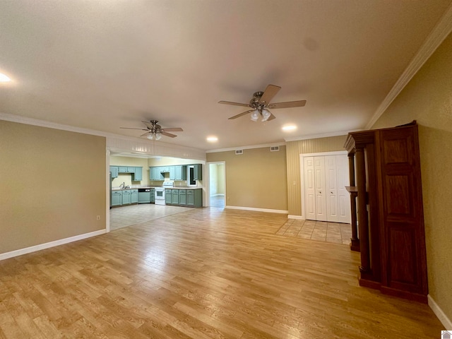 unfurnished living room featuring crown molding, sink, light tile flooring, and ceiling fan