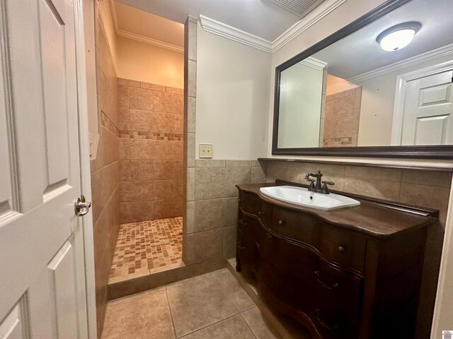 bathroom with crown molding, tile walls, tile floors, and vanity