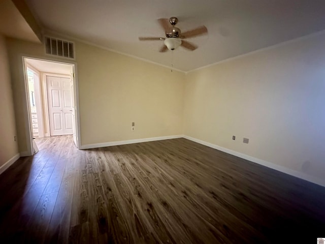 spare room featuring ornamental molding, dark wood-type flooring, and ceiling fan