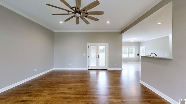 unfurnished living room featuring dark wood-type flooring, ceiling fan, and crown molding