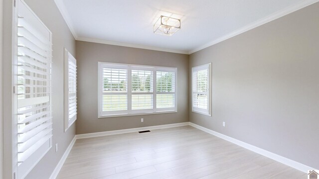 spare room featuring light hardwood / wood-style flooring and crown molding