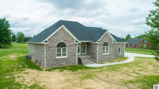 view of front of property featuring a front yard and central AC unit