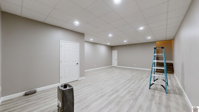 interior space featuring a paneled ceiling and light hardwood / wood-style flooring