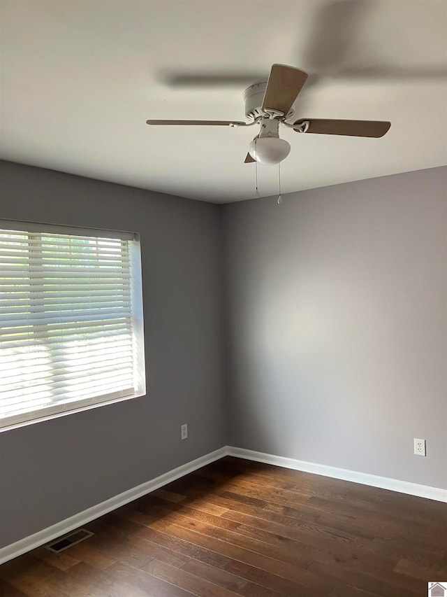 spare room featuring dark wood-type flooring and ceiling fan