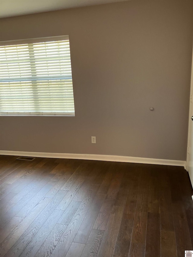 spare room with dark wood-type flooring