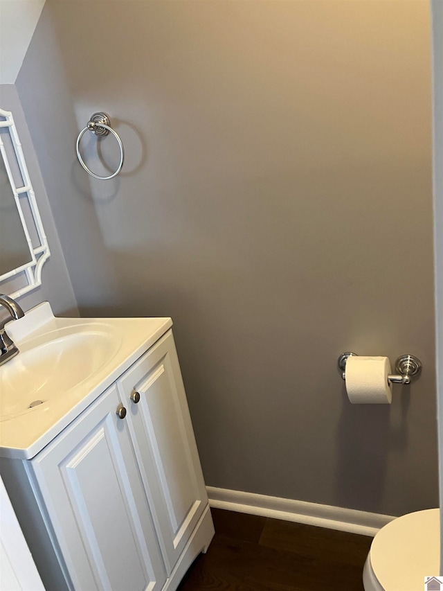 bathroom with vanity, toilet, and hardwood / wood-style floors