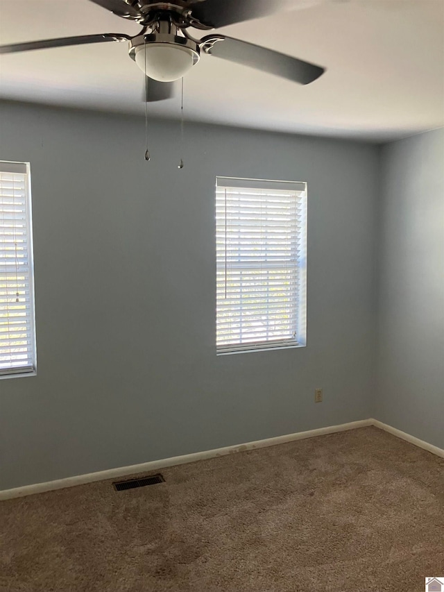 spare room with a wealth of natural light, ceiling fan, and carpet floors