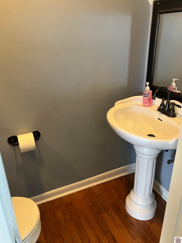 bathroom featuring hardwood / wood-style flooring and toilet