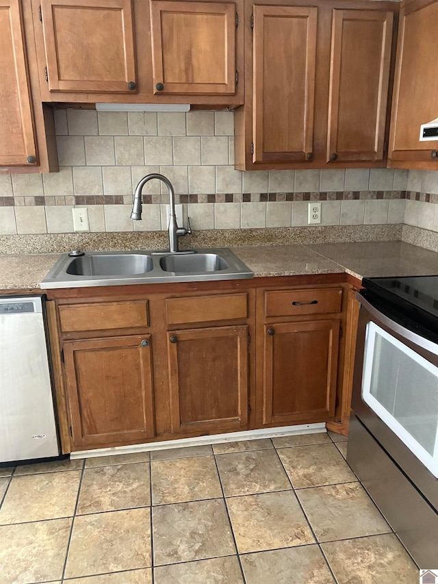 kitchen featuring sink, tasteful backsplash, light tile flooring, and stainless steel appliances