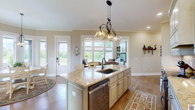 kitchen with a center island with sink, pendant lighting, sink, and stainless steel appliances