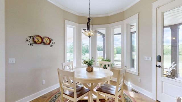 dining area featuring hardwood / wood-style floors, a notable chandelier, and ornamental molding