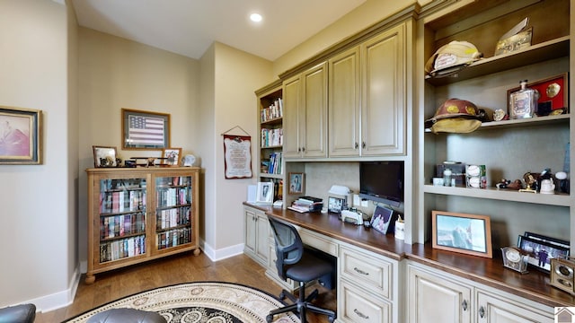 office area with built in desk and dark hardwood / wood-style floors