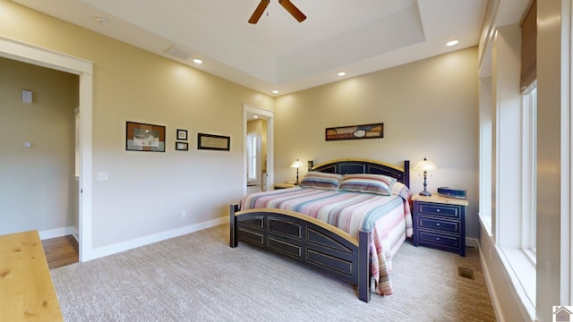 bedroom with ceiling fan and a tray ceiling