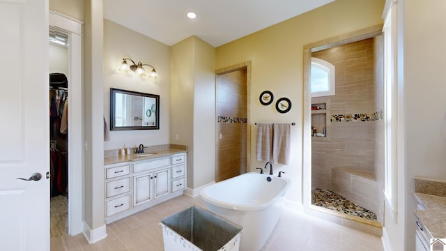 bathroom with tile patterned floors, vanity, and separate shower and tub