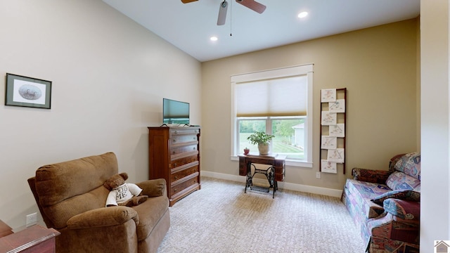 living area with ceiling fan, light colored carpet, and lofted ceiling