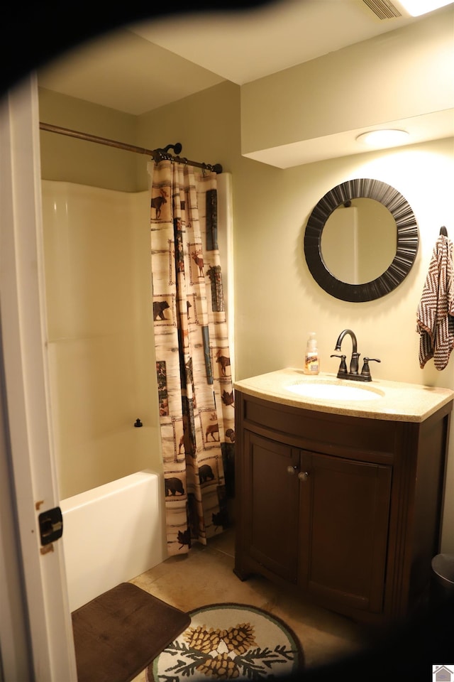 bathroom featuring tile patterned floors, shower / bath combo with shower curtain, and vanity