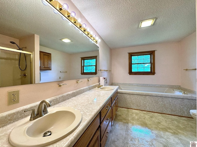 full bathroom with vanity, toilet, a textured ceiling, and shower with separate bathtub