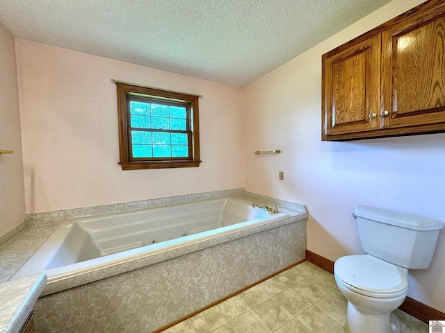 bathroom featuring a bathing tub, toilet, and a textured ceiling