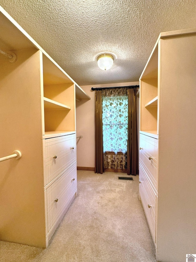 walk in closet featuring light carpet