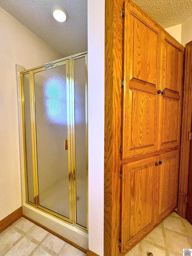 bathroom with a textured ceiling and walk in shower