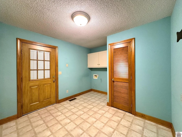 clothes washing area with cabinets, washer hookup, and a textured ceiling