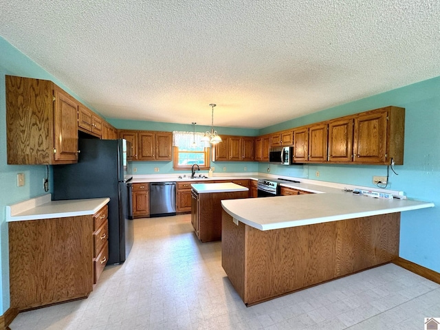 kitchen featuring sink, hanging light fixtures, kitchen peninsula, a notable chandelier, and stainless steel appliances