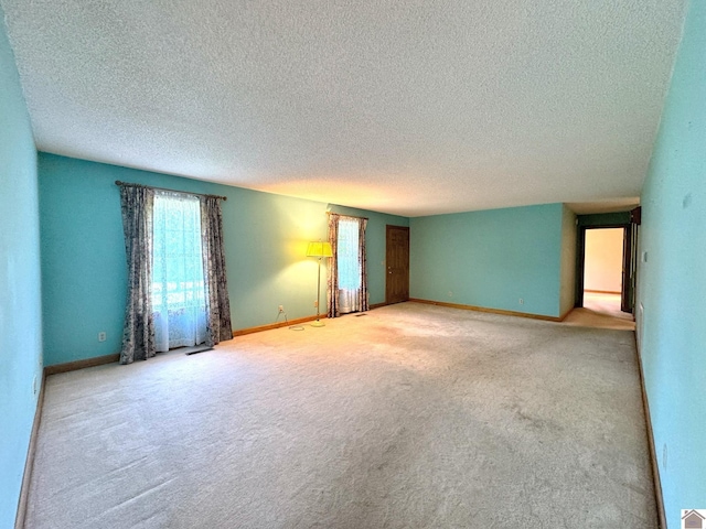 unfurnished room with light colored carpet and a textured ceiling