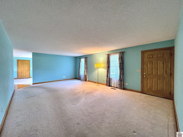 carpeted spare room with a textured ceiling