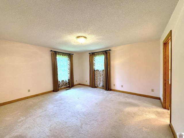 carpeted spare room with a textured ceiling