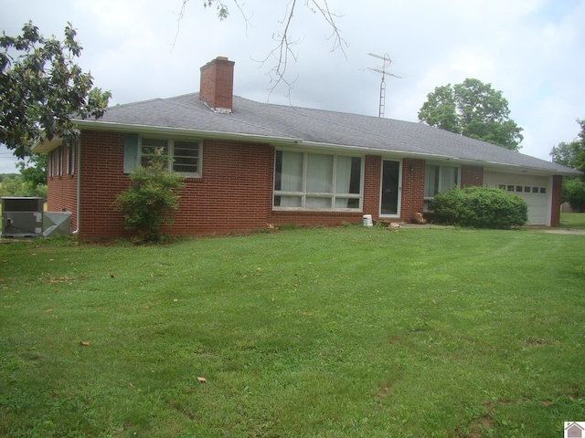 single story home with brick siding, a chimney, a front yard, and a garage