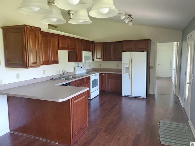 kitchen with sink, white appliances, dark hardwood / wood-style flooring, vaulted ceiling, and kitchen peninsula