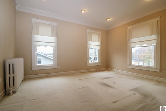 carpeted empty room with radiator heating unit and ornamental molding