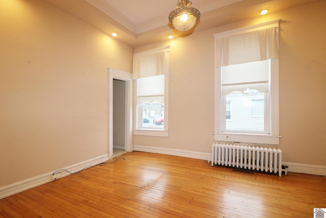 unfurnished room with light wood-type flooring and radiator