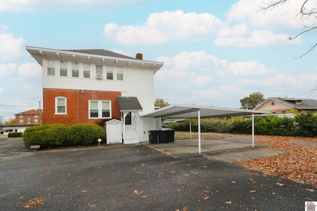 view of front of property with a carport and a storage shed