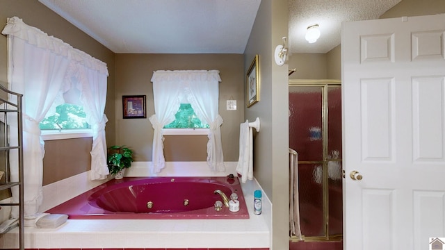 bathroom featuring a textured ceiling and independent shower and bath