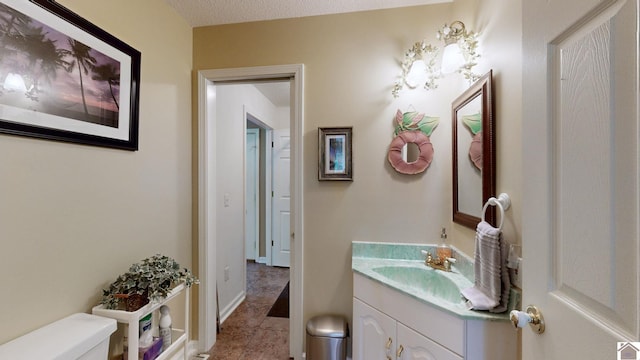 bathroom with tile patterned floors, vanity, toilet, and a textured ceiling