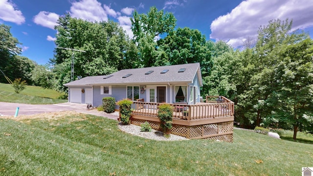 back of house featuring a lawn, a garage, and a wooden deck