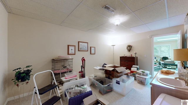 interior space featuring sink and a drop ceiling