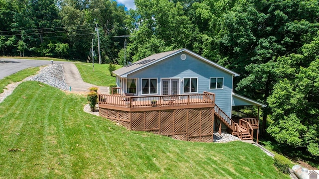 rear view of house featuring a deck and a lawn