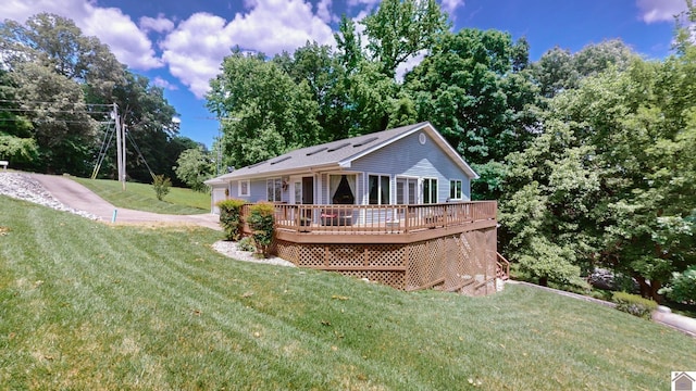 rear view of house featuring a yard and a wooden deck