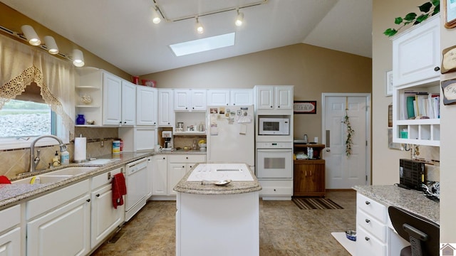 kitchen featuring a kitchen island, white appliances, sink, and white cabinetry