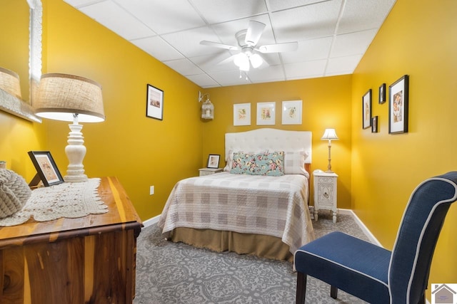 bedroom featuring carpet flooring, a drop ceiling, and ceiling fan