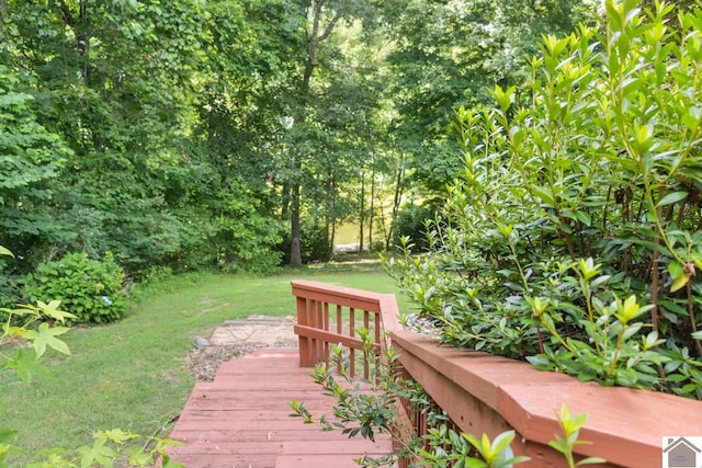 wooden terrace featuring a lawn